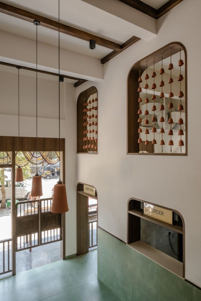 The double-height atrium at Benne & Brew hung with terracotta bells and pendant lamps