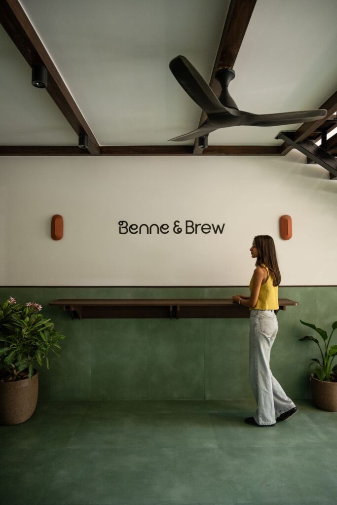 The Benne & Brew lettering on the cream wall above the counter ledge and mint-green wainscoting