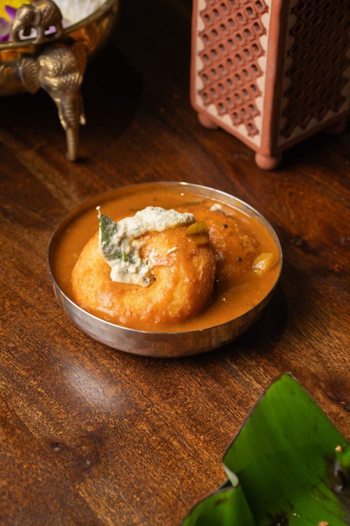 Vada soaking in sambar topped with coconut chutney