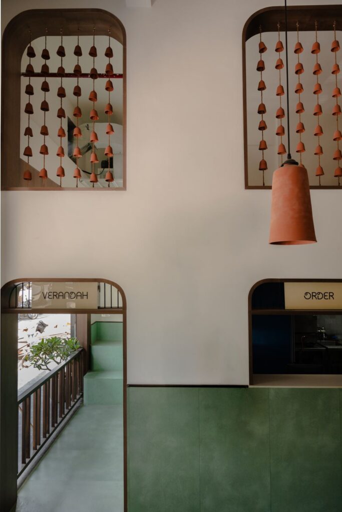 The staircase and double-height wall of terracotta bells at Benne & Brew, Viman Nagar